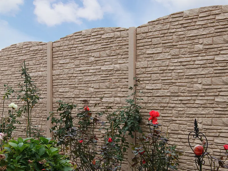 Betonzaun Montanabogen mit roten Blumen davor